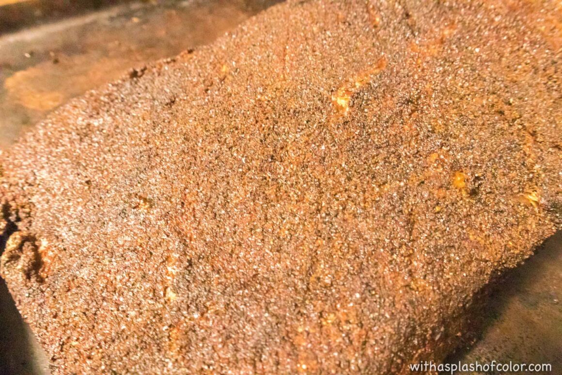 adding seasoning to the brisket